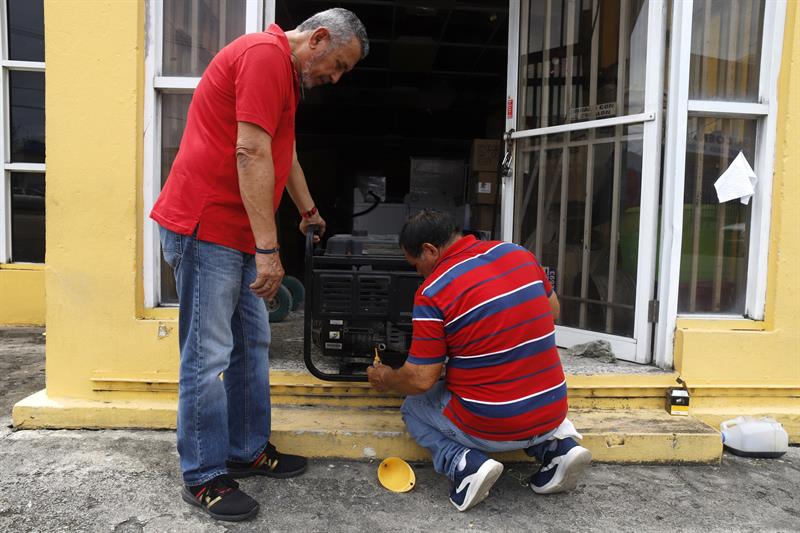 Personas preparan un generador de energía para una casa en Yabucoa, Puerto Rico.