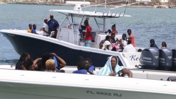 Sobrevivientes del huracán Dorian abordan barcos para ser evacuados.