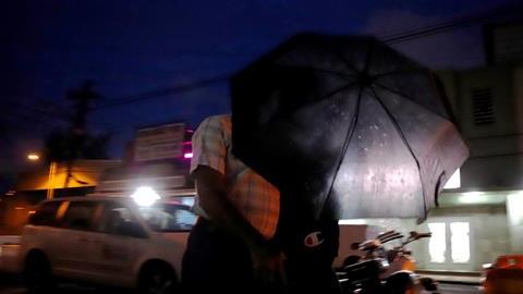 Dos ciudadanos se cubren con una sombrilla durante el paso de la tormenta Karen, en San Juan.