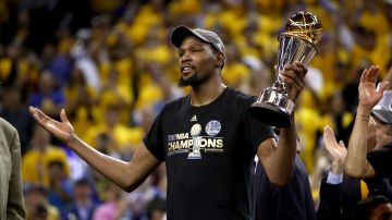 Kevin Durant, con el trofeo de 'MVP' de las Finales en su mano, celebra su primer campeonato de la NBA, la noche del lunes en Oakland.