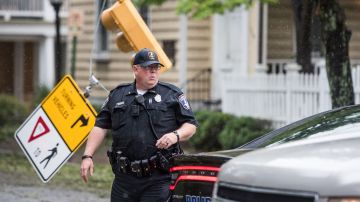 Un policía camina junto a una señal de tráfico dañada en Charleston.