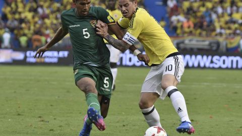 Mario Cuéllar disputa un balón con James Rodríguez en un duelo internacional.