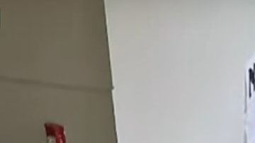 La captura muestra cuando el entrenador abraza al alumno y otro maestro retira el arma.
