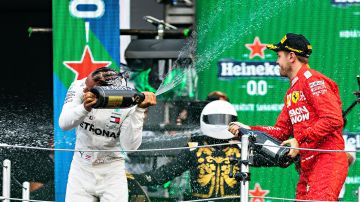 Lewis Hamilton festeja con Sebastian Vettel. Al fondo se aprecia Mario Achi.