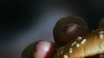 LONDON - JULY 12: In this photo illustration a lady eats a beefburger on July 12, 2007 in London, England. Government advisors are considering plans for a fat tax on foods high in fat to try to help tackle the fight against obesity. (Photo illustration by Cate Gillon/Getty Images)
