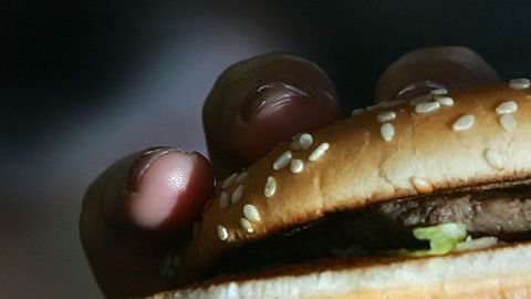 LONDON - JULY 12: In this photo illustration a lady eats a beefburger on July 12, 2007 in London, England. Government advisors are considering plans for a fat tax on foods high in fat to try to help tackle the fight against obesity. (Photo illustration by Cate Gillon/Getty Images)