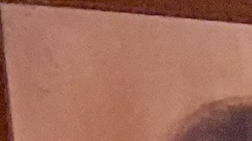 Magdalena Gómez  sostiene su tarjeta de residente en una mano, y en la otra la foto de su esposo, quien a causa de su repentino fallecimiento durante los trámites de residencia, no la pudo obtener. (Araceli Martínez/La Opinión).