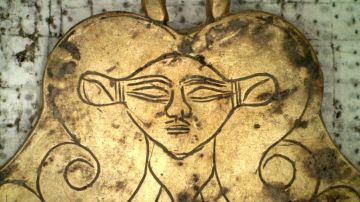 Un colgante de oro con la imagen de una diosa que representa a la muerte.