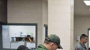 Agentes de inmigración procesan las solicitudes de asilo en la frontera.