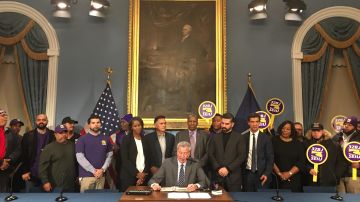El alcalde, Bill de Blasio, firma la ley que amplía la garantía de salario prevalente./Cortesía