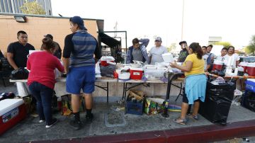 Jornaleros compran alimentos a vendedores ambulantes cerca de la esquina de Union Ave. y Shatto St.