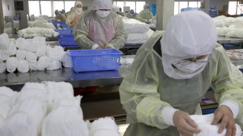 Trabajadores en una fábrica de mascarillas en Nantong (China)