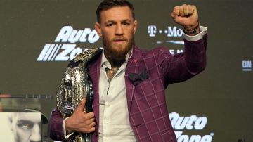 El irlandés presume uno de sus cinturones de campeón durante una conferencia de prensa