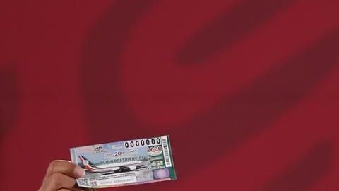 AMLO muestra su billete para la rifa del avión presiencial.