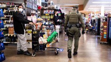 Un alguacil patrulla un supermercado en Los Ángeles, para que se mantenga el distanciamiento social.