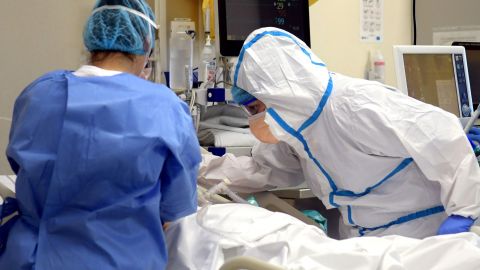 Especialistas bien protegidos atienden a un paciente en la sala de un hospital.