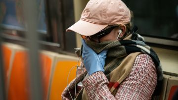 Una mujer con una máscara protectora, es vista en un vagón del metro en la Terminal Grand Central en la ciudad de Nueva York. Jeenah Moon / Getty Images)