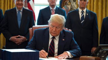 El presidente Trump firma la Ley CARES de estímulo económico.