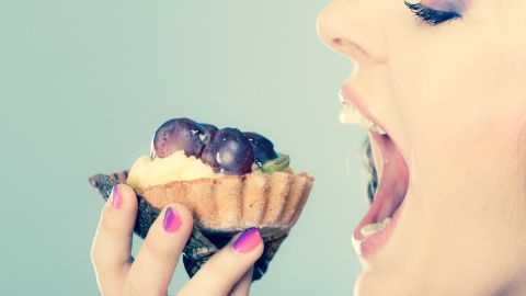 woman face profile open mouth eating cake