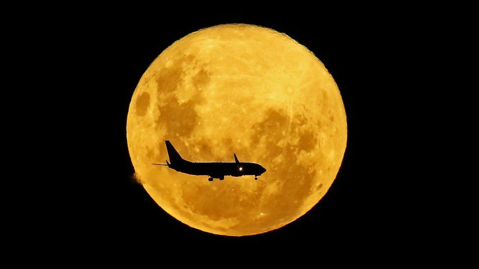 Un avión pasa por delante de la Luna, en Curitiba, Brasil, el 9 de marzo de 2020.