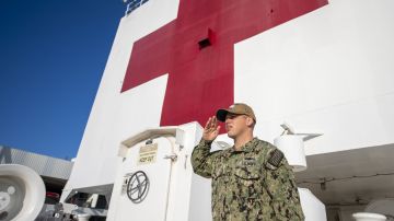 Un oficial de la Marina haciendo un saludo a la bandera a bordo del USNS Mercy.