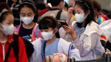 Menores portan mascarillas anticoronavirus en un aeropuerto de Singapur.