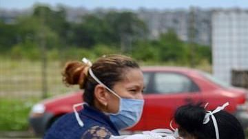 Mujer llora ante el ataúd de su familiar.