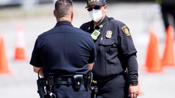 Foto de archivo de un oficial del Departamento de Bomberos del Condado de Los Ángeles mientras conversa con un oficial de policía.