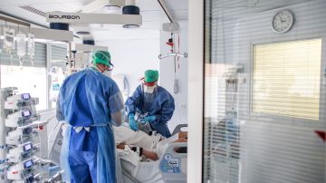 Doctores y enfermeras con equipo de protección atienden a un paciente con COVID-19 en Francia.