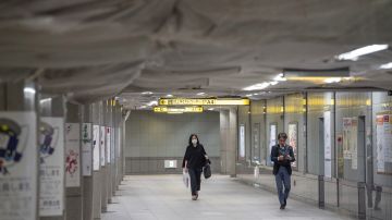 Personas caminan a distancia en el Metro de Tokio, Japón.