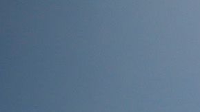 Una mujer pasando con una bicicleta frenta a un cartel de "playa cerrada" en South Beach, en Miami Beach.