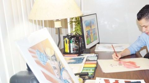 Jiovanny López en su mesa de trabajo dando los últimos toques a uno de sus dibujos.