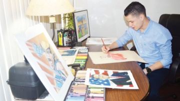 Jiovanny López en su mesa de trabajo dando los últimos toques a uno de sus dibujos.