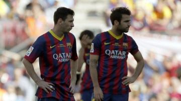 Los jugadores del Barcelona, Leonel Messi (i) y Cesc Fábregas, muestran su decepción