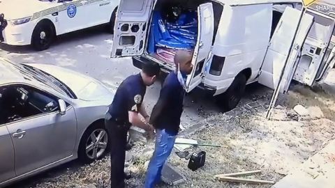 Captura del momento en que el doctor es esposado por el agente de policía.