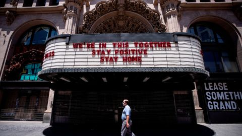 Los Angeles (United States), 27/05/2020.- A man wearing a face mask walks past the Million Dollar Theater which front reads 'We're In This Together, Stay Positive, Stay Home', amid the coronavirus pandemic in Los Angeles, California, USA, 27 May 2020. Los Angeles County officials have announced on 26 May, moving forward with the reopening of the County, with restaurants allowed to open with restrictions. (Abierto, Estados Unidos) EFE/EPA/ETIENNE LAURENT