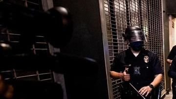 Una mujer cae de su bicicleta mientras la Policía de L.A. le bloquea el paso.