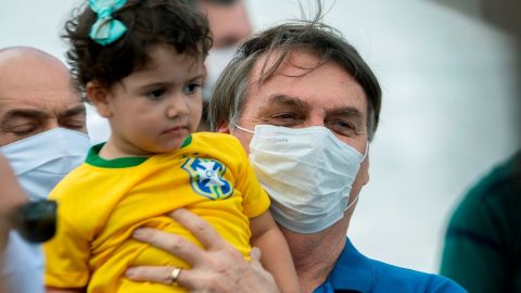 AME549. BRASILIA (BRASIL), 17/05/2020.- El presidente brasileño, Jair Bolsonaro, levanta a una niña en una manifestación de apoyo este domingo en la entrada del Palacio do Planalto en Brasilia (Brasil). Bolsonaro estuvo acompañadopor once ministros y destacó la gran presencia de seguidores pese a las medidas de los gobiernos regionales para evitar las aglomeraciones como herramienta para combatir el COVID-19. EFE/Joédson Alves.