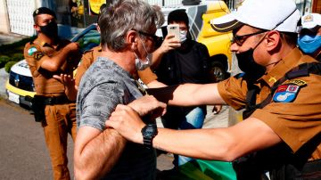 Un policía revisa a un manifestante en calles de Brasilia.