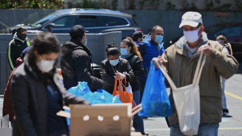 Neoyorquinos reciben alimentos en la despensa de Voices of Hagar en la iglesia de San Marcos AME, en Queens.