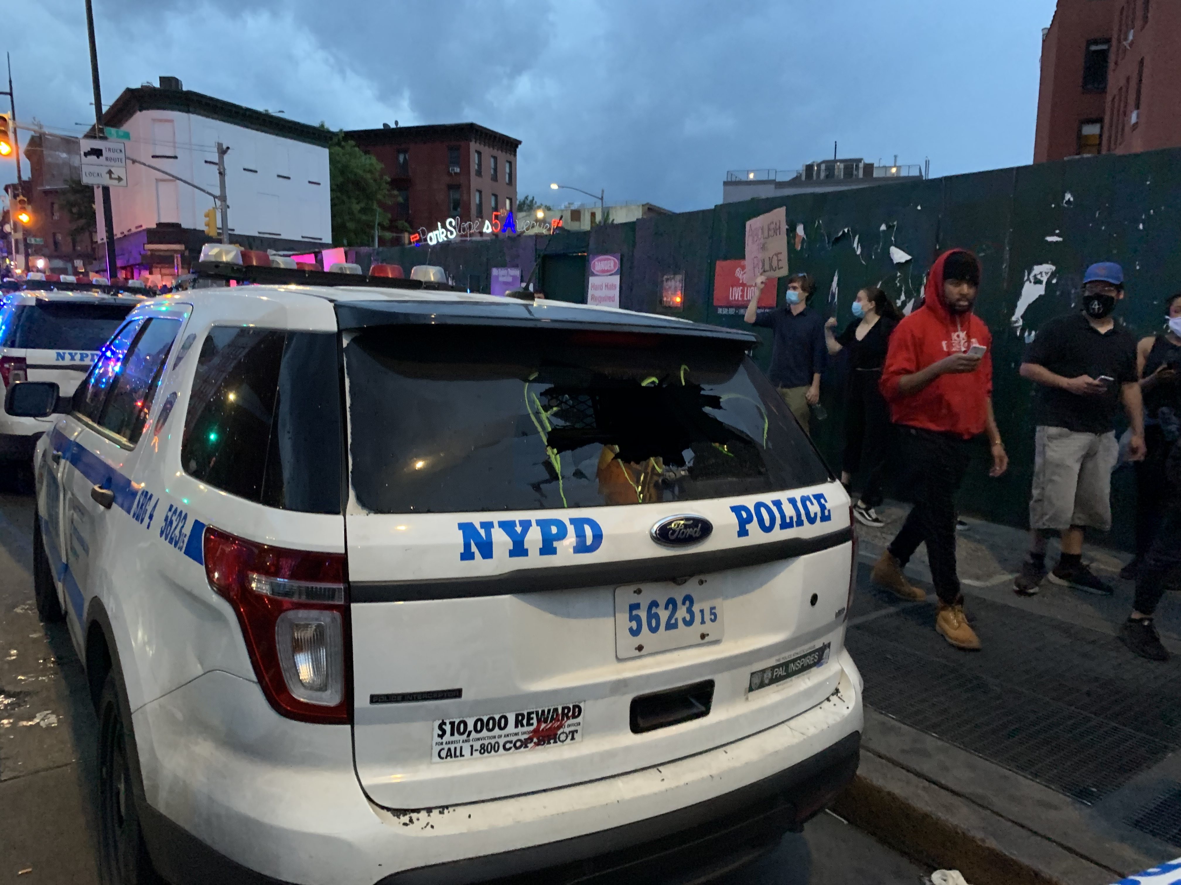 Algunos coches de la Policía sufrieron daños. / Foto: Rafael Cores, El Diario NY
