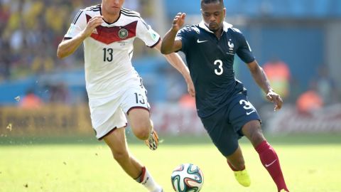 Thomas Müller y Patrice Evra disputan un balón en el Mundial de Brasil 2014.