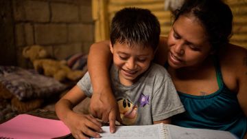 Viviana González, de 38 años, y su hijo, Ismael Estuardo, de 10 años, beneficiarios del proyecto educativo Los Patojos, que les brinda materiales para que estudien en casa y reciben ayuda alimentaria por la crisis económica que les afecta, fueron registrados al estudiar, en Jocotenango, (Sacatepéquez, Guatemala)