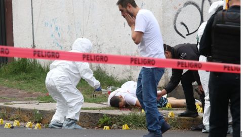 Elementos de la fiscalía de Ciudad de México levantan el cuerpo de uno de los hombres asesinados el martes.
