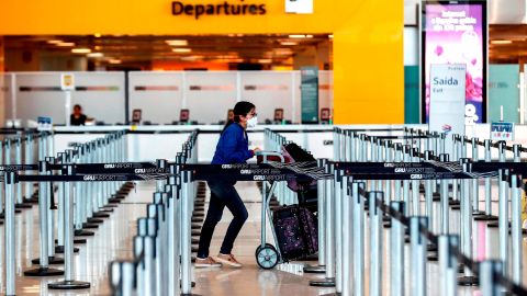 Una mujer usa máscaras como precaución contra la propagación del nuevo coronavirus COVID-19 en el Aeropuerto Internacional de Sao Paulo.