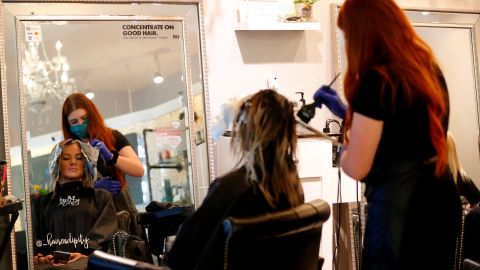 Vacaville (United States), 01/05/2020.- A customer uses her phone while having her hair styled by Cecily Clay, an employee of owner, Lia Rivera of Hairendipity Salon, after Rivera opened her business two days ago in defiance of the COVID-19 Stay-at-Home Order in Vacaville, California, USA, 30 April 2020. California Governor Gavin Newsom said hair salons fall under the state's third phase of reopening California businesses. California is currently in the first phase. Rivera is willing to risk a 1,000 US dollar fine, instead of losing thousands of dollars of staying closed. (Abierto, Estados Unidos) EFE/EPA/JOHN G. MABANGLO