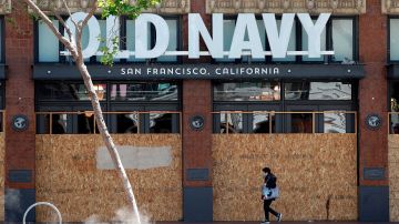 Una persona pasa por una tienda minorista de Old Navy cerrada en San Francisco, California.