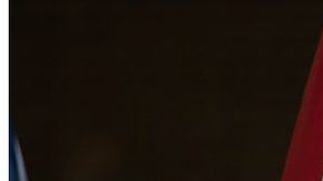 Un supremacista hace el saludo nazi con una bandera de la confederación y las cruces símbolo del Ku Klux Klan.