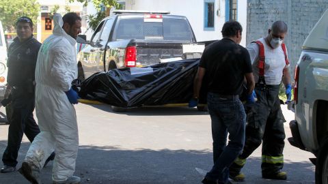 MEXICO-CRIME-CORPSES
Forensic personnel carry one of the corps found at the crime scene of a clandestine grave located inside a house in Guadalajara, Jalisco State, Mexico on August 3, 2018. - The prosecutor´s office of the state of Jalisco reported at least ten bodies have been found in a clandestine grave, Guadalajara is the second Mexican city and has a strong presence of organised crime. (Photo by ULISES RUIZ / AFP) (Photo credit should read ULISES RUIZ/AFP via Getty Images)