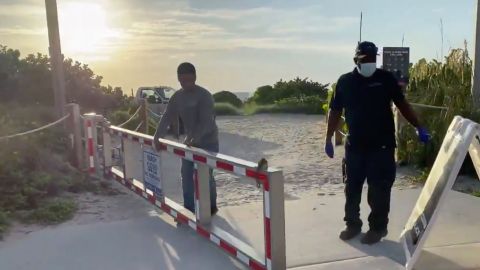 Empleados de la ciudad despejaban los accesos a la playa de Miami Beach para que los residentes y turistas puedan volver a entrar.